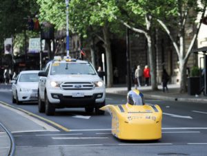 一般道路をゴールに向かって走ってくるレース車